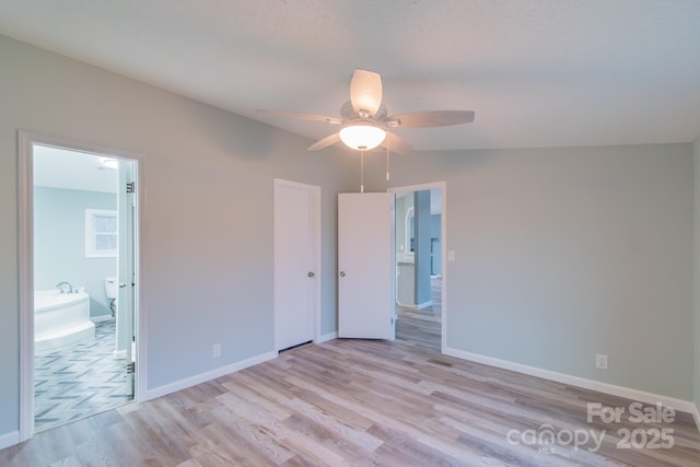 unfurnished bedroom featuring vaulted ceiling, ceiling fan, ensuite bathroom, and light hardwood / wood-style floors