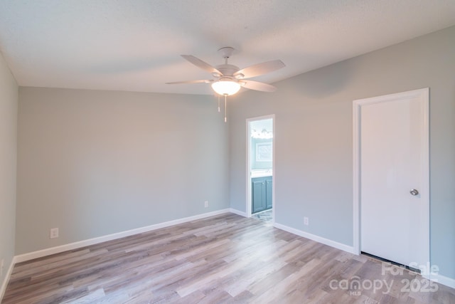 empty room featuring ceiling fan, a textured ceiling, and light wood-type flooring