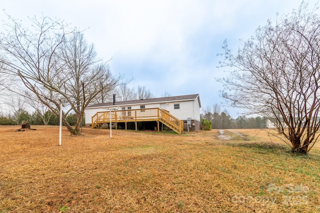 rear view of property with a deck and a lawn