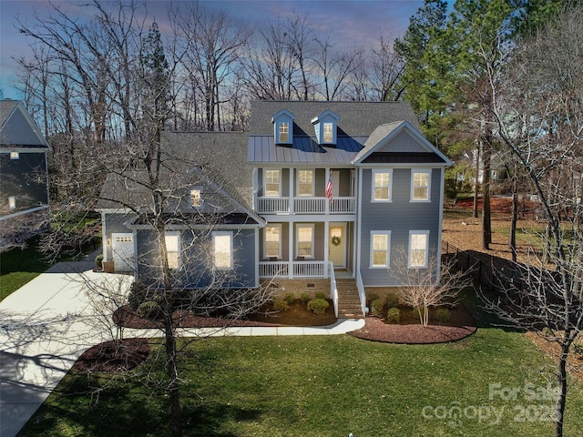 view of front of property with concrete driveway, a balcony, a standing seam roof, a porch, and a front yard