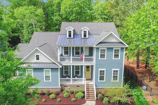 view of front of house with metal roof, covered porch, a standing seam roof, and a balcony