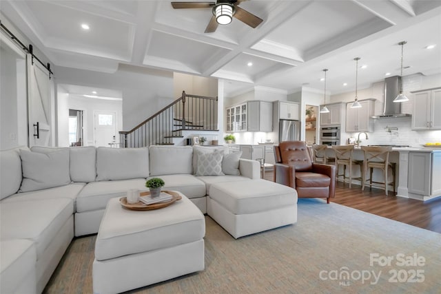 living area featuring a barn door, stairs, coffered ceiling, beam ceiling, and recessed lighting