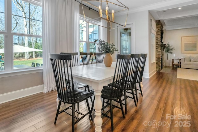 dining room with baseboards, wood finished floors, a notable chandelier, and ornamental molding
