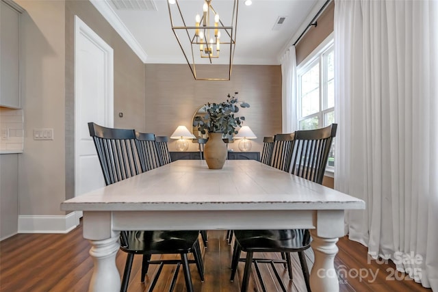 dining room featuring crown molding, an inviting chandelier, baseboards, dark wood-style flooring, and visible vents