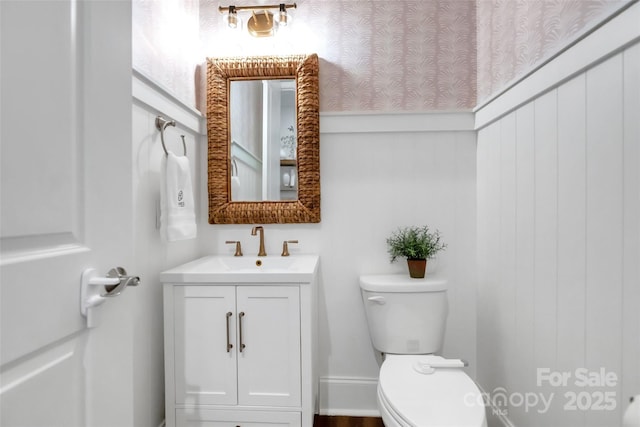 half bathroom with vanity and toilet