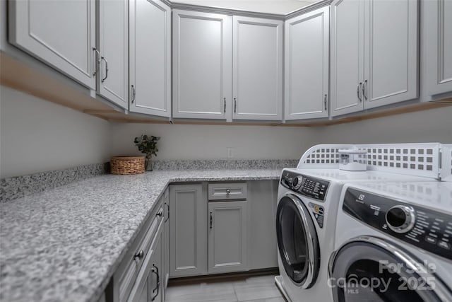 laundry area featuring separate washer and dryer and cabinet space