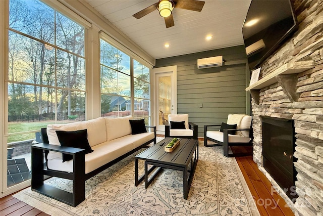 sunroom with an outdoor living space with a fireplace, ceiling fan, and a wall mounted air conditioner