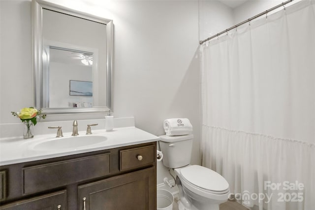 bathroom featuring vanity, curtained shower, and toilet
