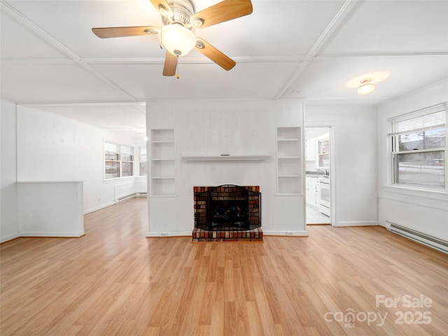 unfurnished living room with built in features, ceiling fan, baseboard heating, a fireplace, and light hardwood / wood-style floors