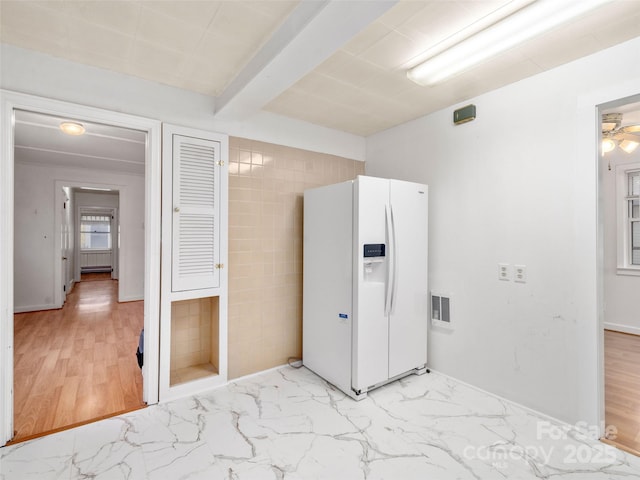 interior space with beam ceiling and white fridge with ice dispenser