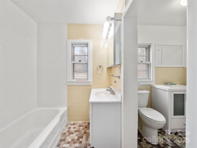 bathroom with vanity, tile walls, and toilet