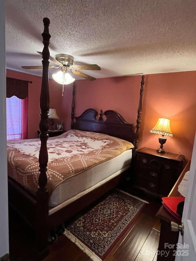 bedroom featuring hardwood / wood-style floors, a textured ceiling, and ceiling fan