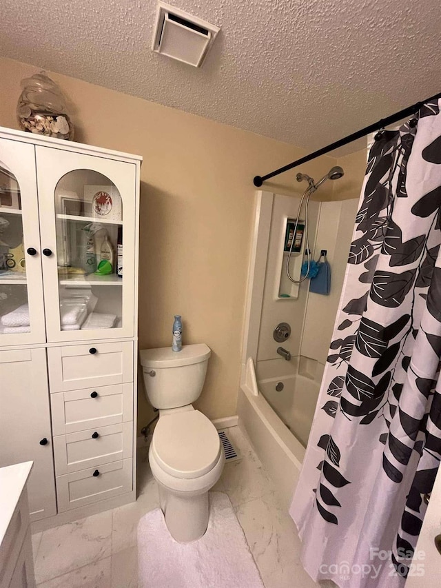 bathroom with shower / bathtub combination with curtain, a textured ceiling, and toilet