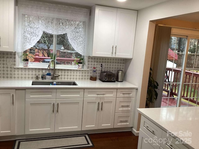 bar with backsplash, dark hardwood / wood-style flooring, sink, and white cabinets