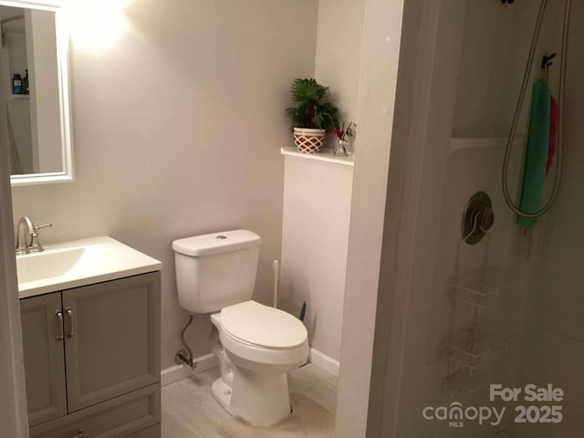 bathroom featuring vanity, toilet, and a shower