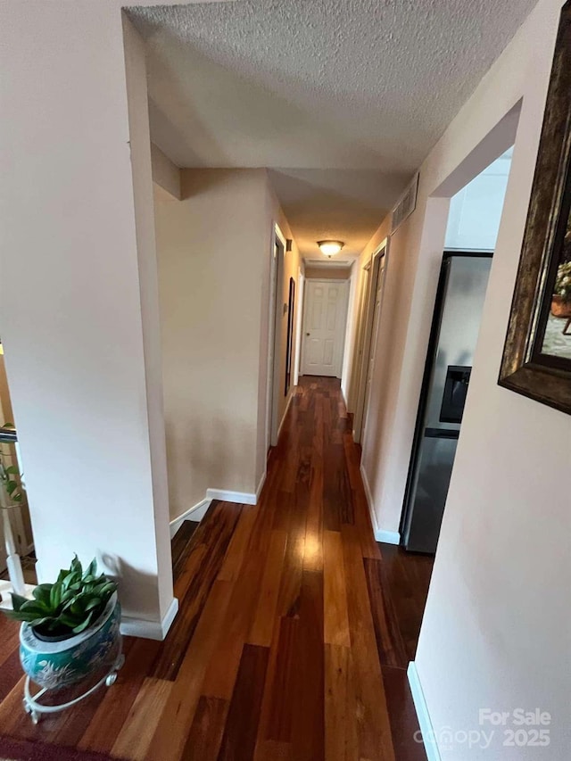 hall featuring dark hardwood / wood-style floors and a textured ceiling