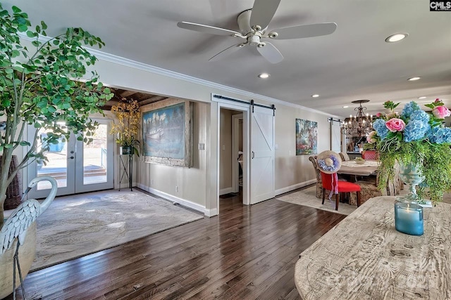 dining space with ornamental molding, a barn door, dark wood-style flooring, and baseboards