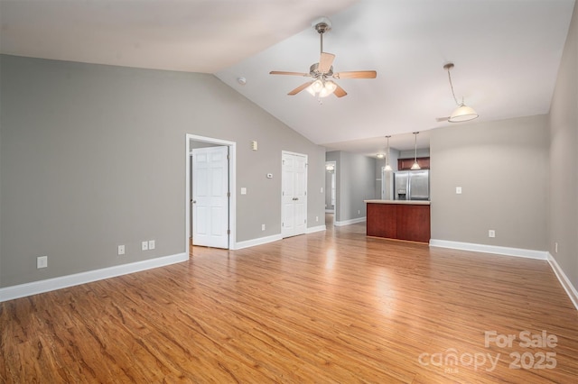 unfurnished living room with ceiling fan, high vaulted ceiling, and light hardwood / wood-style floors