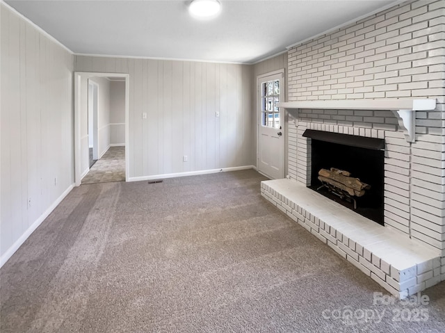 unfurnished living room featuring a fireplace, crown molding, and carpet floors