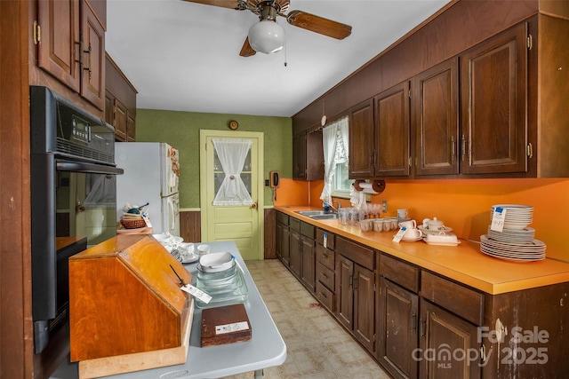 kitchen featuring white fridge, sink, oven, and ceiling fan