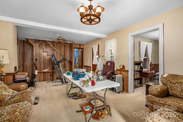 interior space with radiator, beam ceiling, ceiling fan with notable chandelier, and light colored carpet