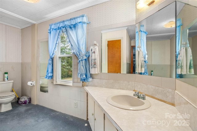 bathroom featuring tile walls, vanity, crown molding, and toilet