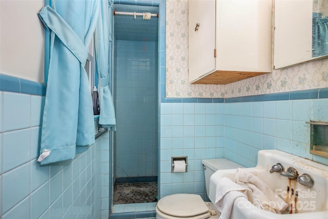 bathroom featuring a tile shower, tile walls, and toilet