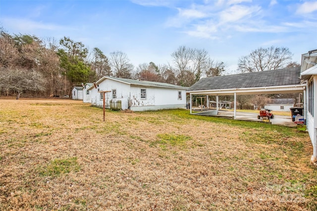 rear view of house with a patio and a lawn