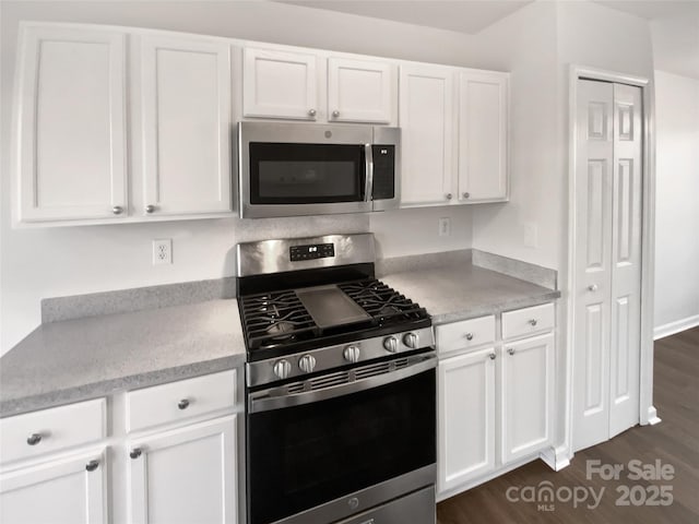 kitchen featuring dark hardwood / wood-style floors, white cabinets, and stainless steel appliances