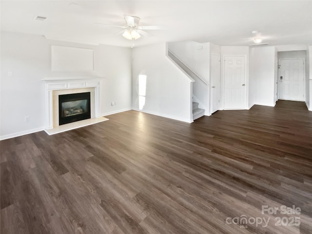 unfurnished living room featuring dark hardwood / wood-style flooring and ceiling fan