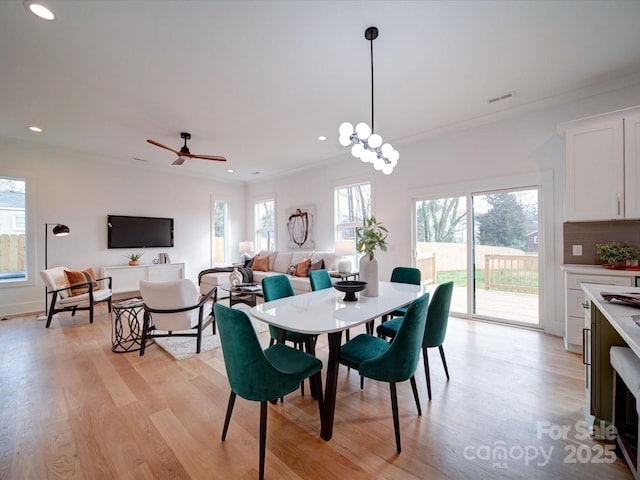 dining room featuring crown molding, light hardwood / wood-style floors, and ceiling fan