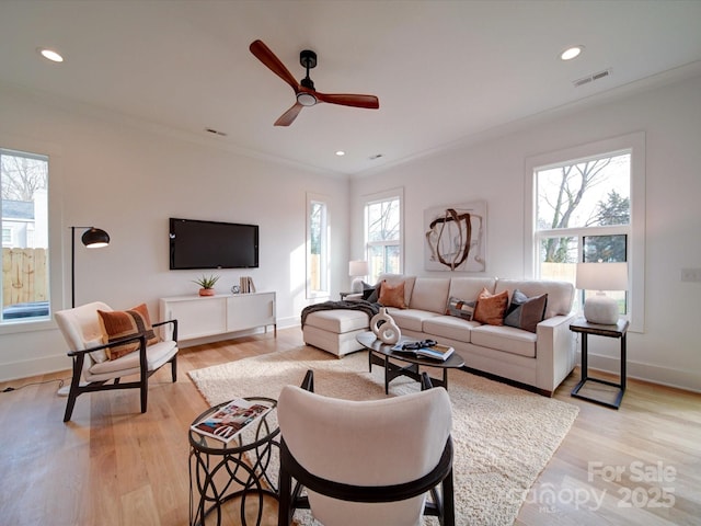 living room with crown molding, ceiling fan, and light hardwood / wood-style floors