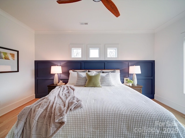 bedroom featuring ornamental molding, light hardwood / wood-style floors, and ceiling fan