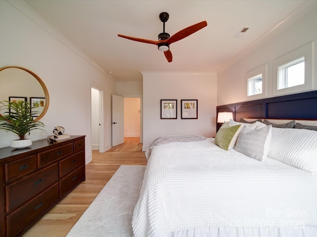 bedroom with crown molding, ceiling fan, and light hardwood / wood-style floors