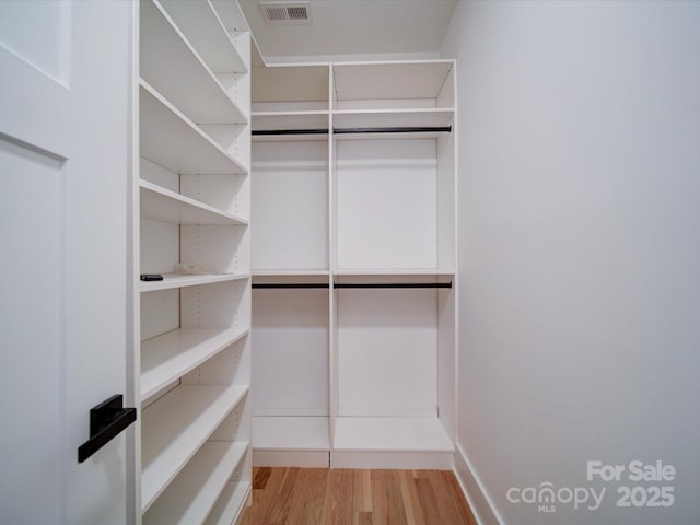 walk in closet with light wood-type flooring