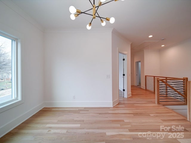 spare room with crown molding, plenty of natural light, and light wood-type flooring