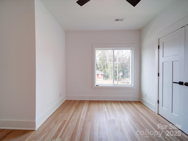 spare room with ceiling fan and light wood-type flooring