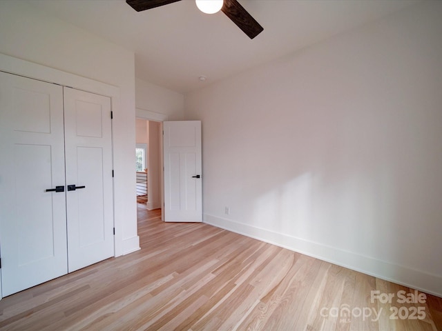 unfurnished bedroom with light hardwood / wood-style flooring, a closet, and ceiling fan