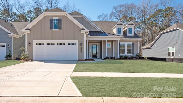 craftsman house with driveway, a standing seam roof, board and batten siding, and a front yard