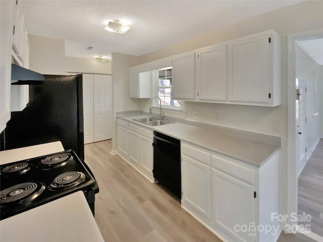 kitchen featuring range hood, sink, white cabinets, and black appliances