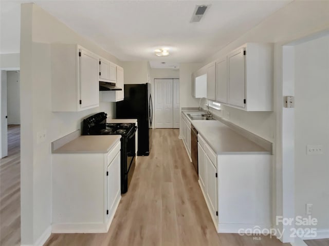 kitchen with white cabinetry, sink, light hardwood / wood-style flooring, and black appliances