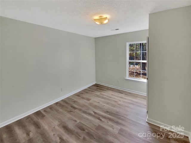 empty room featuring light hardwood / wood-style floors and a textured ceiling