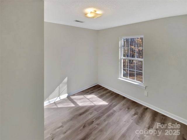 spare room with hardwood / wood-style flooring and a textured ceiling