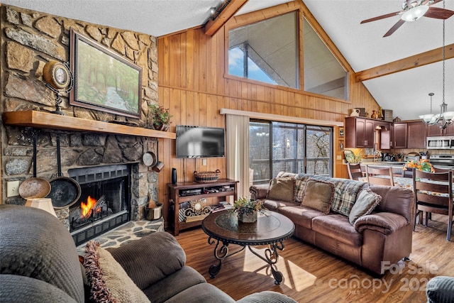 living room with beamed ceiling, a fireplace, light hardwood / wood-style flooring, and a wealth of natural light