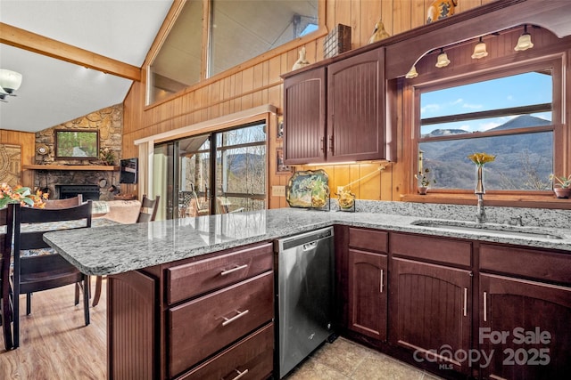 kitchen featuring sink, wooden walls, dishwasher, kitchen peninsula, and a mountain view