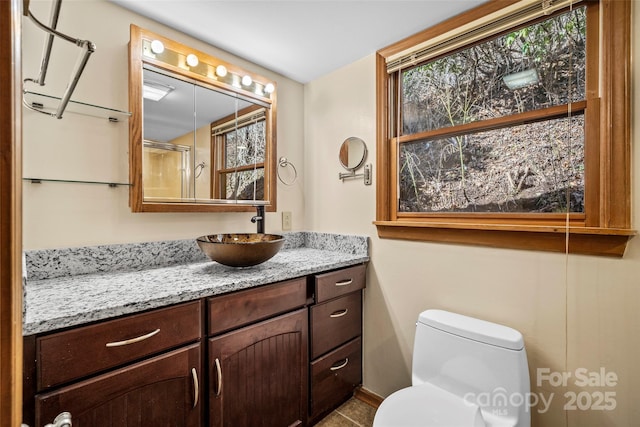 bathroom featuring vanity, an enclosed shower, and toilet