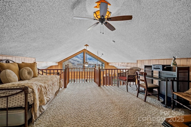 bedroom featuring vaulted ceiling, carpet flooring, a textured ceiling, and wooden walls