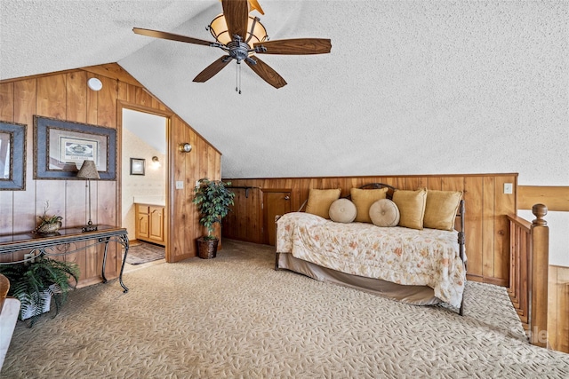 carpeted bedroom featuring vaulted ceiling, ceiling fan, a textured ceiling, and wood walls