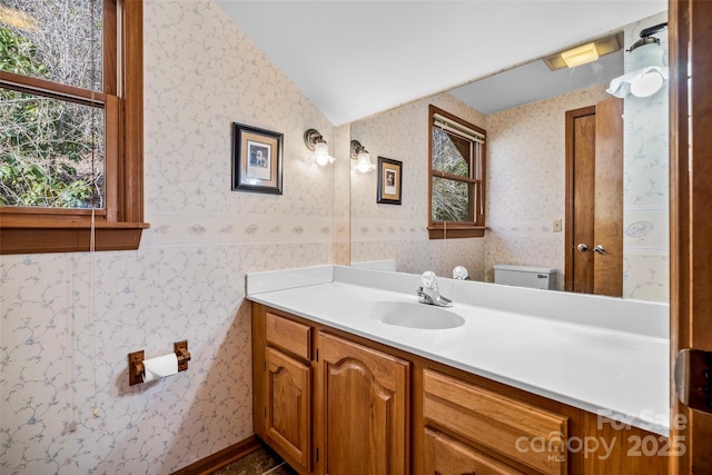 bathroom featuring vaulted ceiling, vanity, and toilet