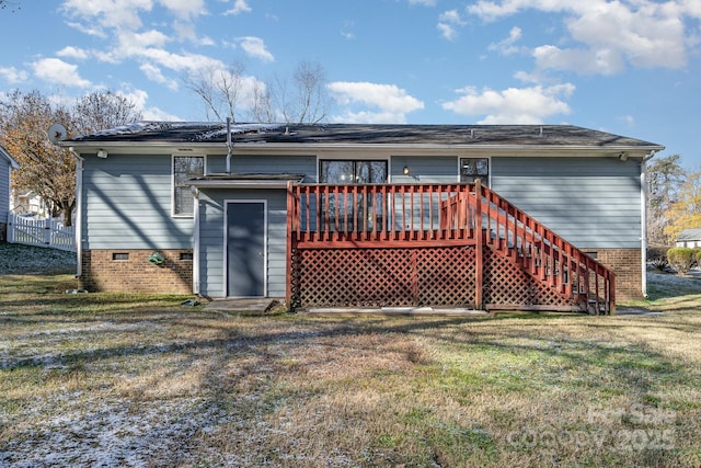 back of property featuring a wooden deck and a yard